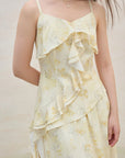 Light yellow floral dress with ruffled layers on a plain background
