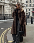 Person wearing a brown fur coat on a city street
