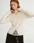 Woman wearing a cream sweater with lace details on a white background, featuring the brand 'DUSHU'.