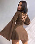 Woman wearing a brown dress with a back design against a neutral background