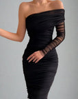 A sleeveless, one-shoulder midi dress with a V-neckline, featuring a sheath silhouette and decorative folds. The dress is predominantly black with a patterned hem.