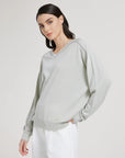 Woman wearing a light gray sweatshirt on a white background
