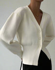 White cardigan worn by a person against a neutral background