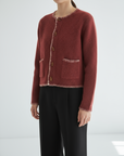 Red textured cardigan worn by a person on a white background