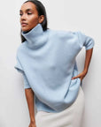 Woman wearing a light blue turtleneck sweater against a white background