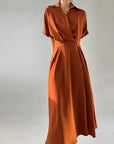 Orange dress on a mannequin against a plain background