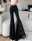 Person wearing black lace pants in a modern living room.