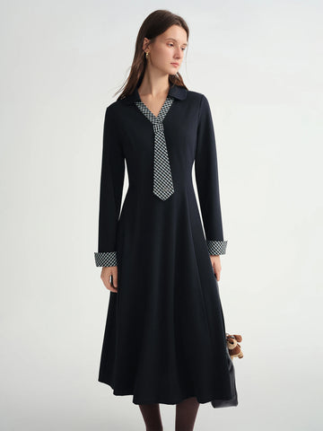 Woman wearing a black dress with a patterned collar against a white background