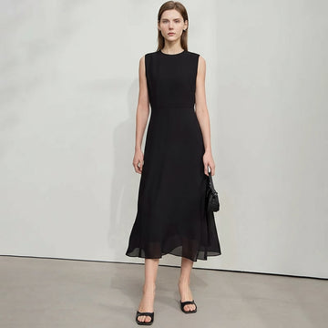 Woman wearing a black dress with a plain background, featuring the brand 'Amii'.