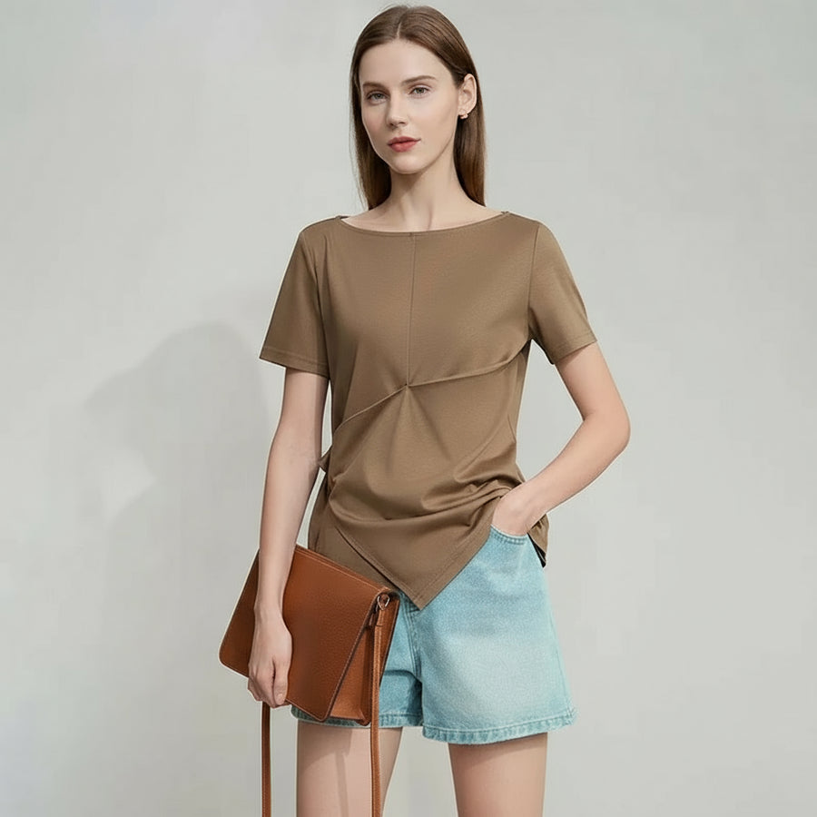 Woman wearing a brown top and denim shorts on a plain background with AMII branding.