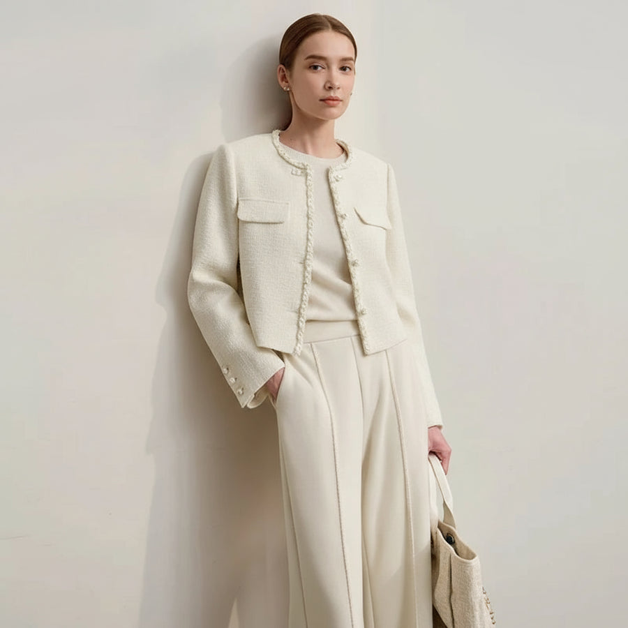 Woman wearing a beige suit with 'Amii' branding on a light background