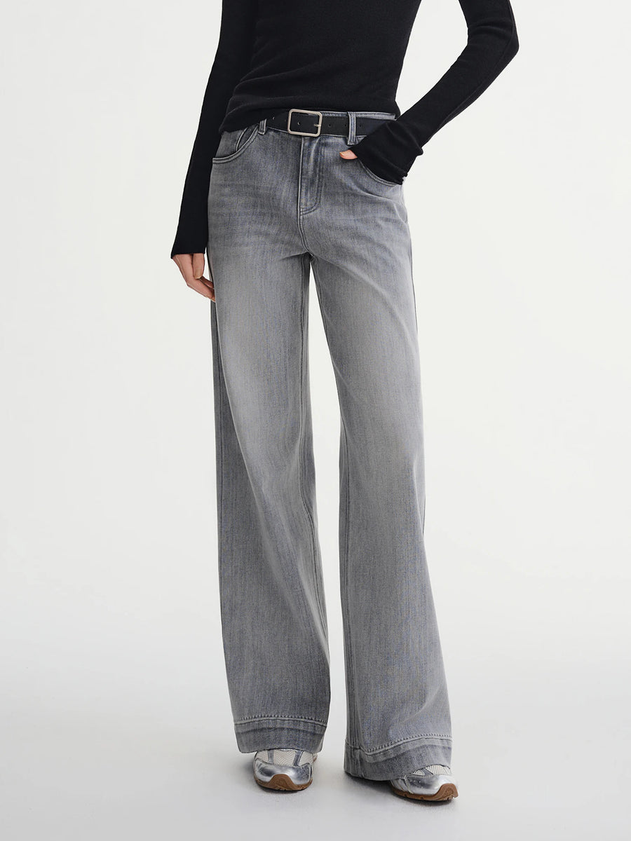 Person wearing gray wide-leg jeans on a white background