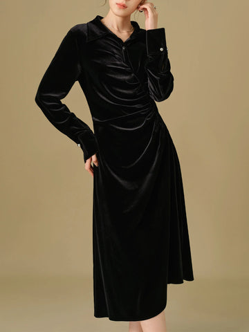 Black velvet dress worn by a model on a beige background