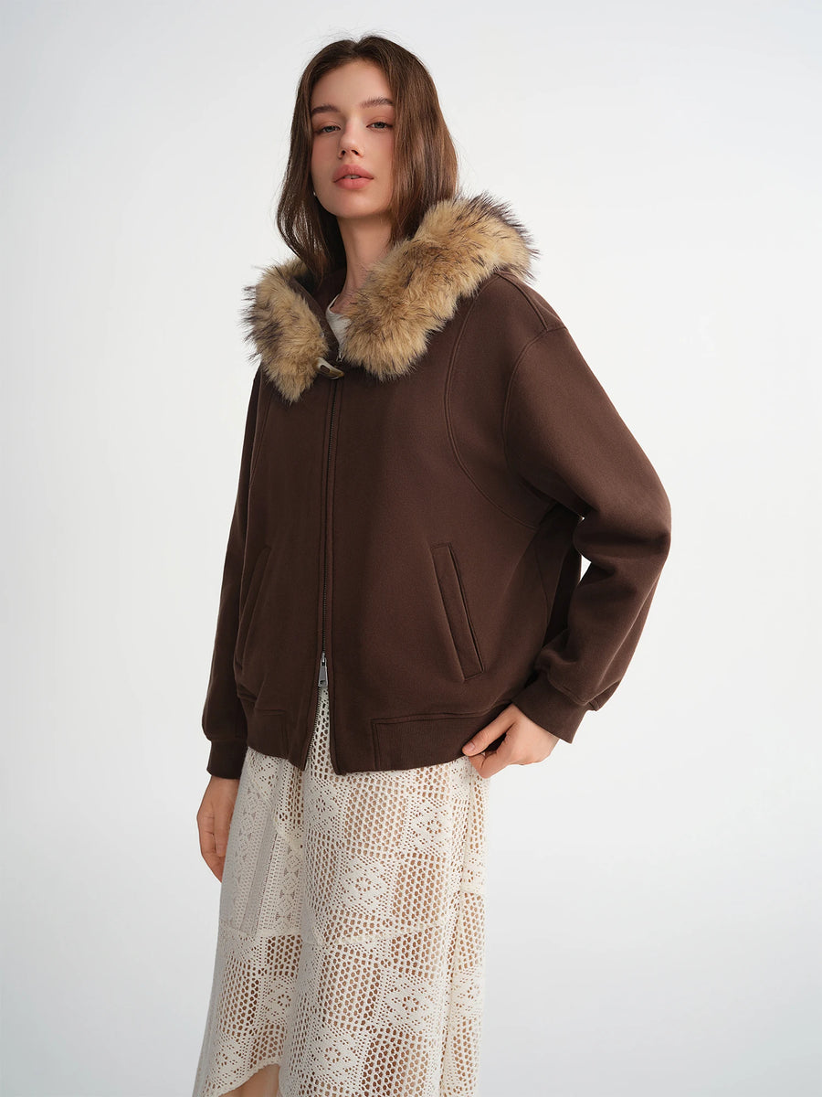 Woman wearing a brown jacket with fur hood on a white background