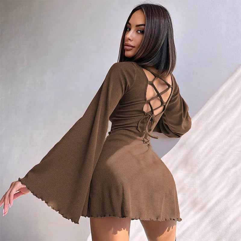Woman wearing a brown dress with a back design against a neutral background