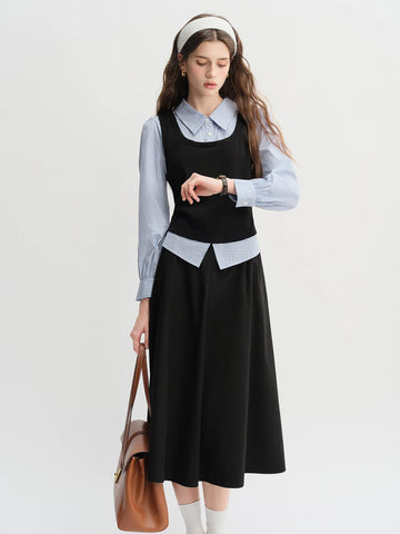 Woman wearing a black dress over a light blue shirt with a white background