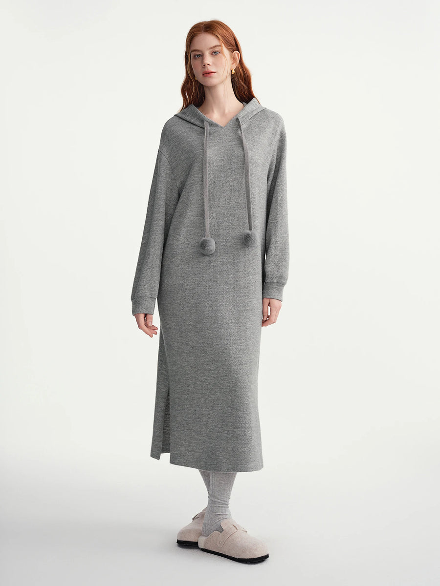 Woman wearing a gray hooded dress on a white background