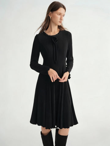 Woman wearing a black dress with long sleeves on a white background, branded 'DUSHU'.