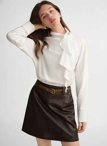 Woman wearing a white blouse and black leather skirt on a light gray background with 'DUSHU' branding.
