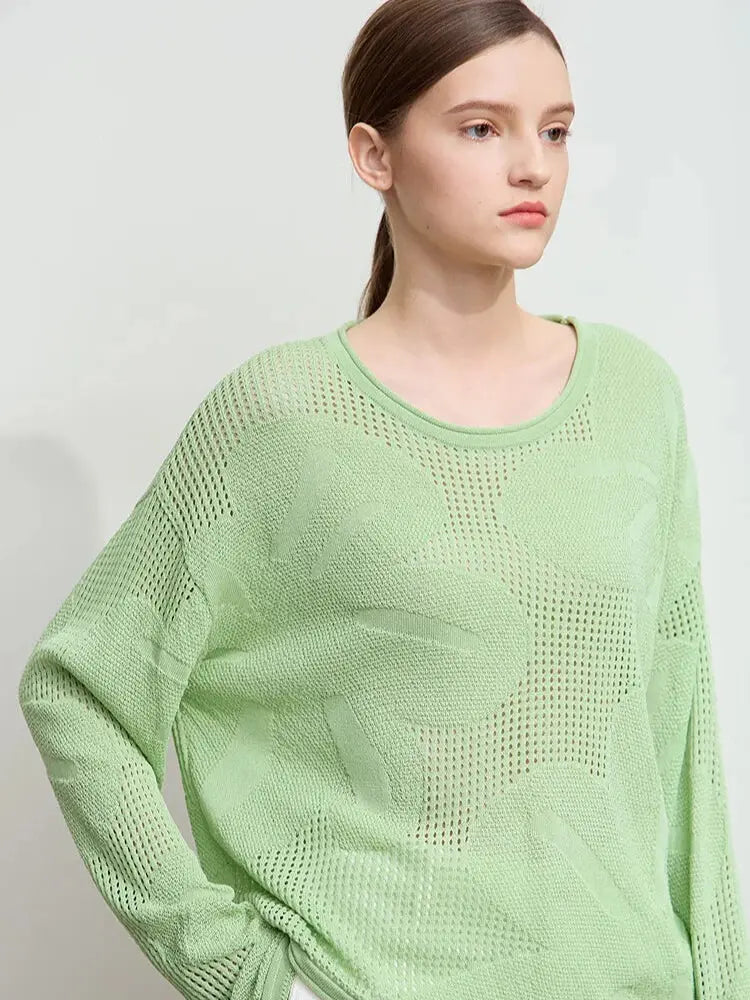 Woman wearing a light green sweater against a plain background