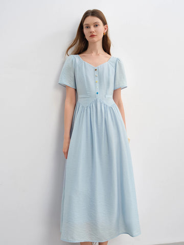 Woman wearing a light blue dress against a white background