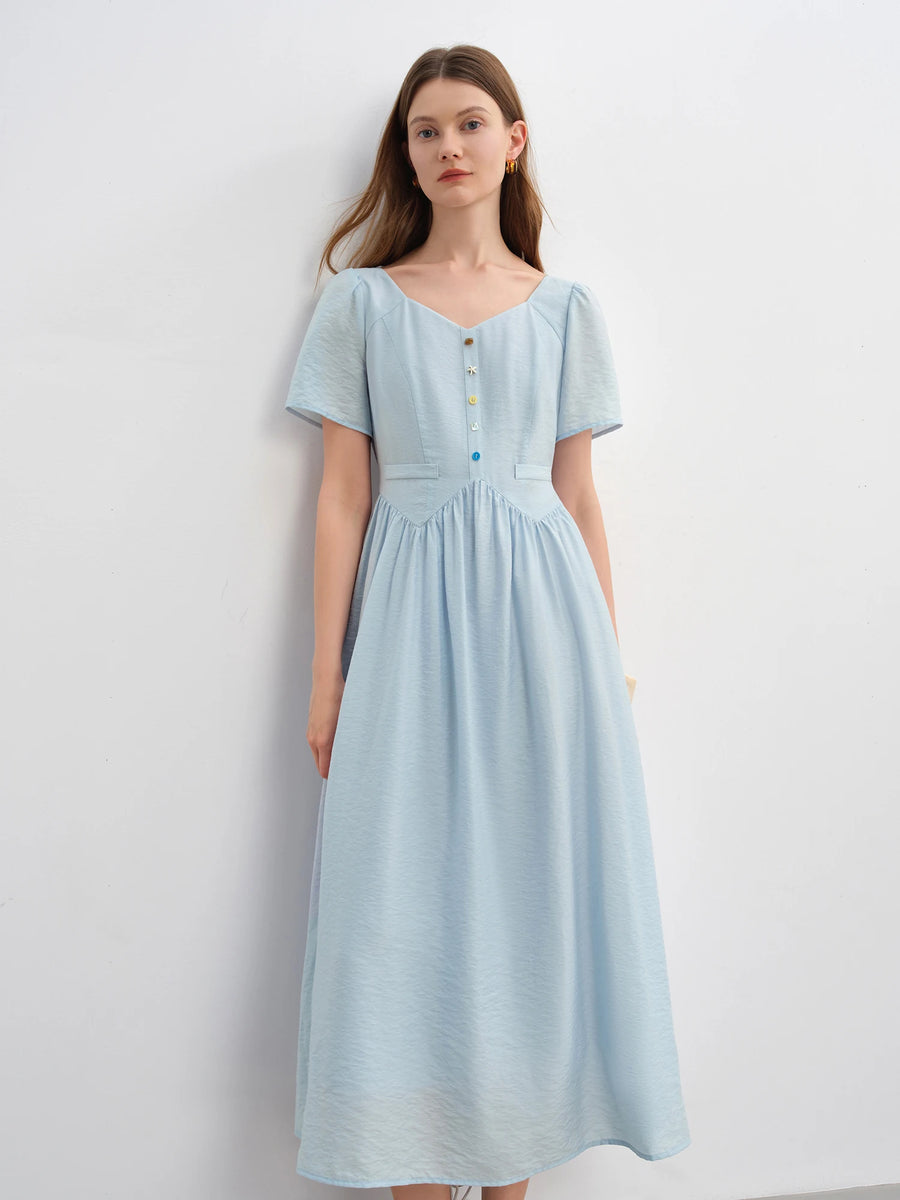 Woman wearing a light blue dress against a white background