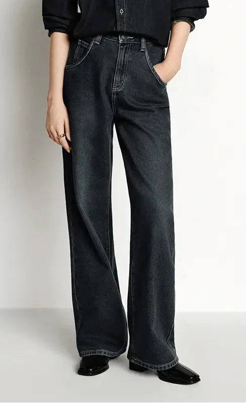 Person wearing black wide-leg jeans on a white background.