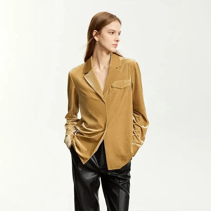 Woman wearing a mustard yellow blazer and black pants on a white background