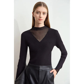 Woman wearing a black long-sleeve top with mesh detail against a white background