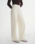 Person wearing white wide-leg pants on a white background