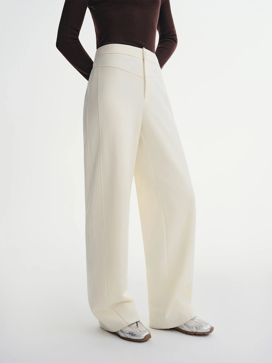 Person wearing white wide-leg pants on a white background