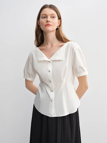 Woman wearing a white blouse with short sleeves on a plain background