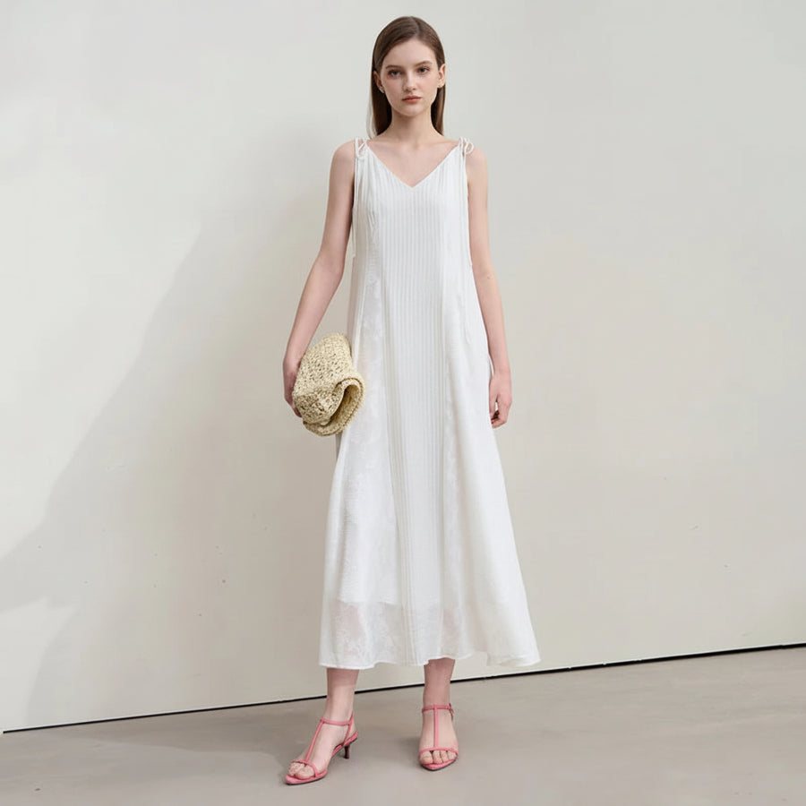 Woman wearing a white dress with a plain background, featuring the brand 'Amii'.