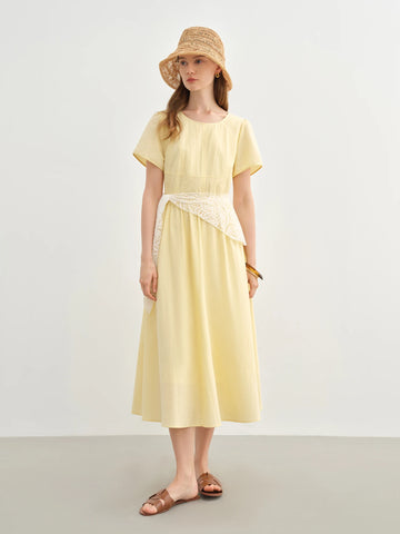 Woman wearing a yellow dress and straw hat on a plain background