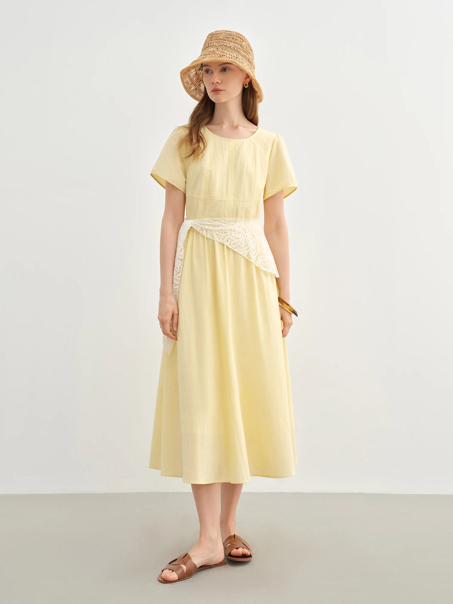 Woman wearing a yellow dress and straw hat on a plain background