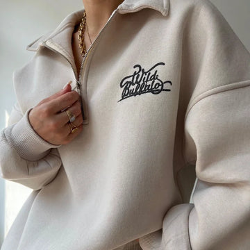 Beige hoodie with 'Wild Buffalo' logo worn by a person