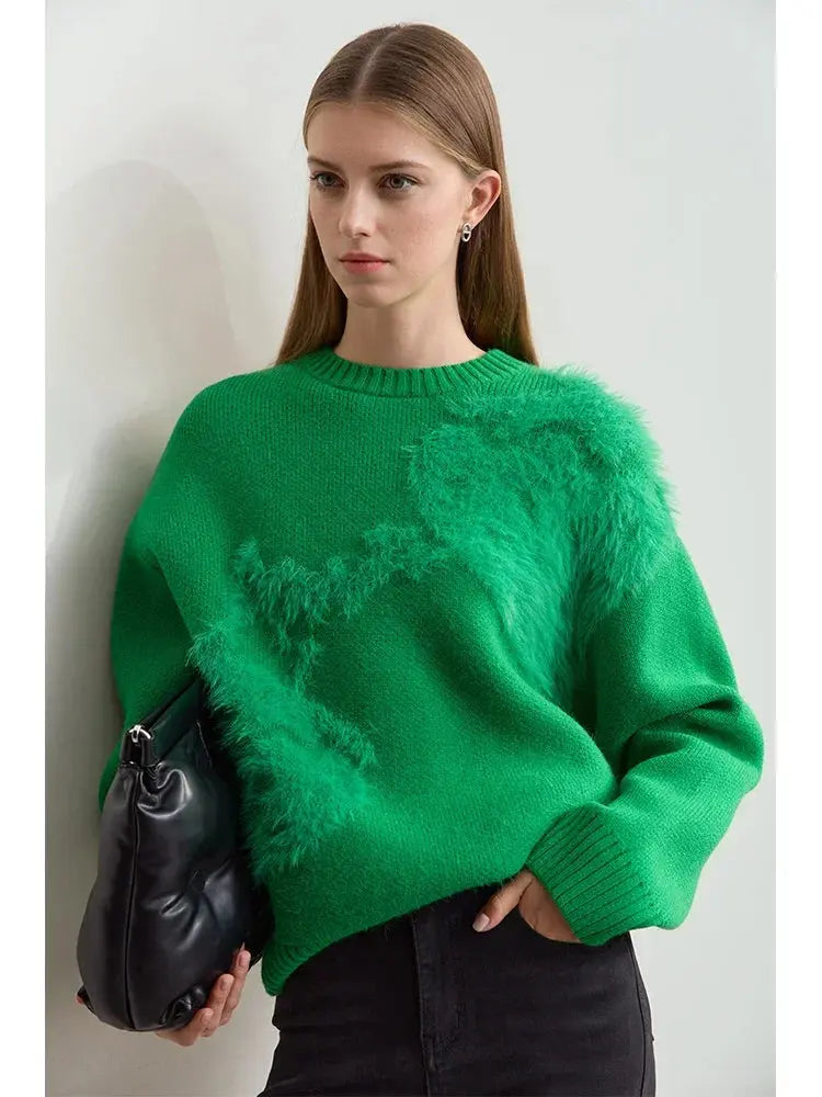 Woman wearing a green sweater holding a black bag against a light background