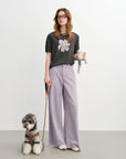 Woman holding a coffee cup with a dog on a leash against a white background