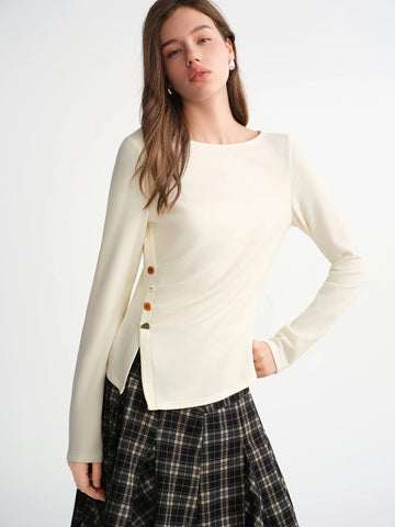 Woman wearing a cream-colored cardigan with button details on a white background
