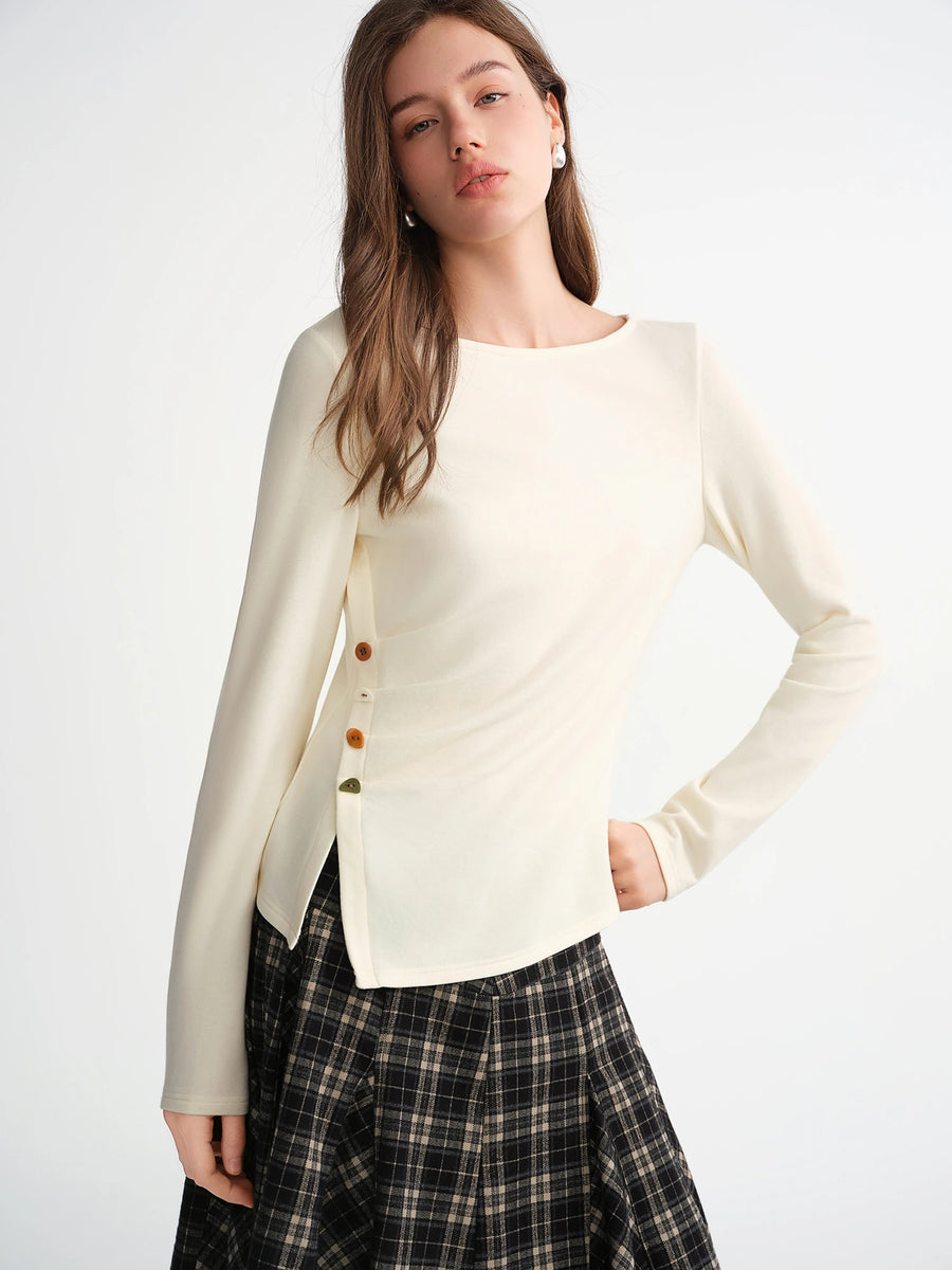 Woman wearing a cream-colored cardigan with button details on a white background