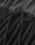 Close-up of a black dress with a drawstring detail, featuring the brand 'Amii'.