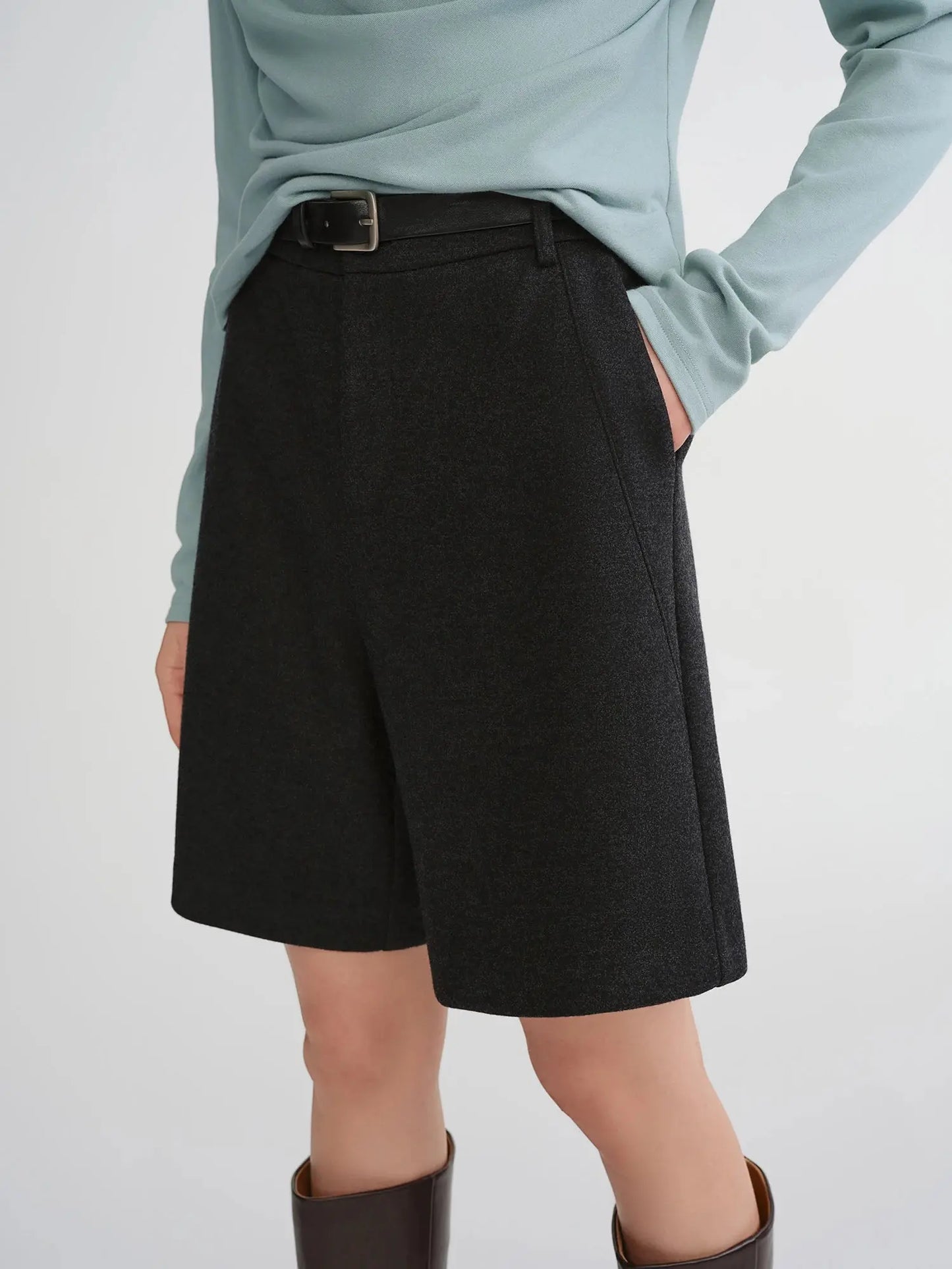 Person wearing a light blue top and black skirt 