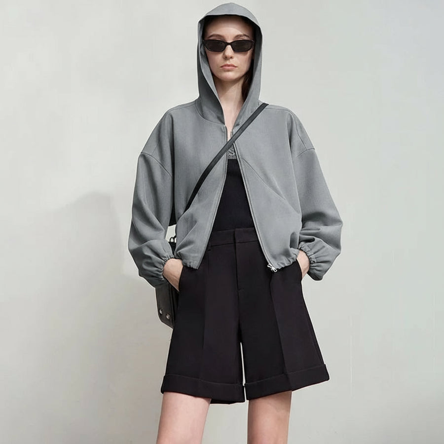 Person wearing a gray hoodie and black shorts with 'Amii' branding.