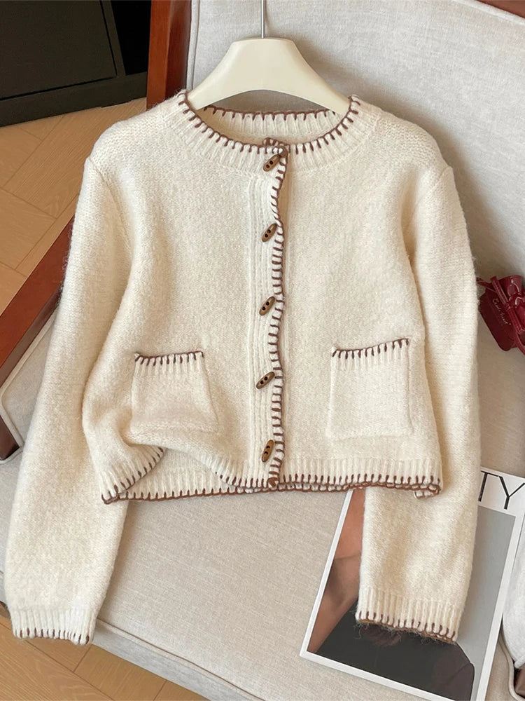 Beige cardigan with brown buttons on a hanger