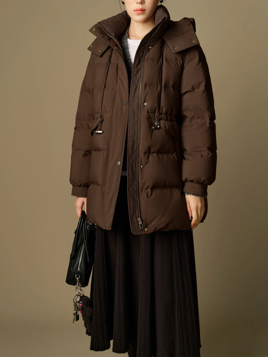 Person wearing a brown puffer coat against a beige background