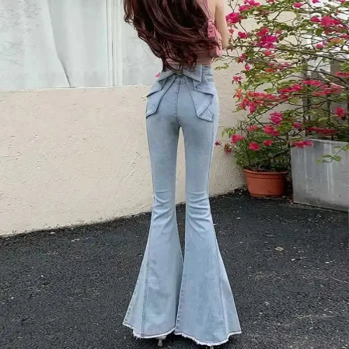 Light blue flared jeans worn by a person with flowers in the background