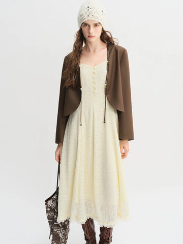 Woman wearing a brown jacket, white dress with lace details, and brown boots on a white background