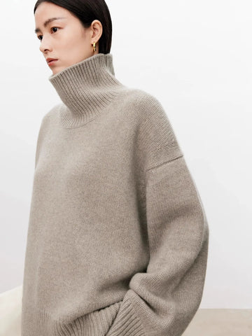 Woman wearing a beige turtleneck sweater against a plain background