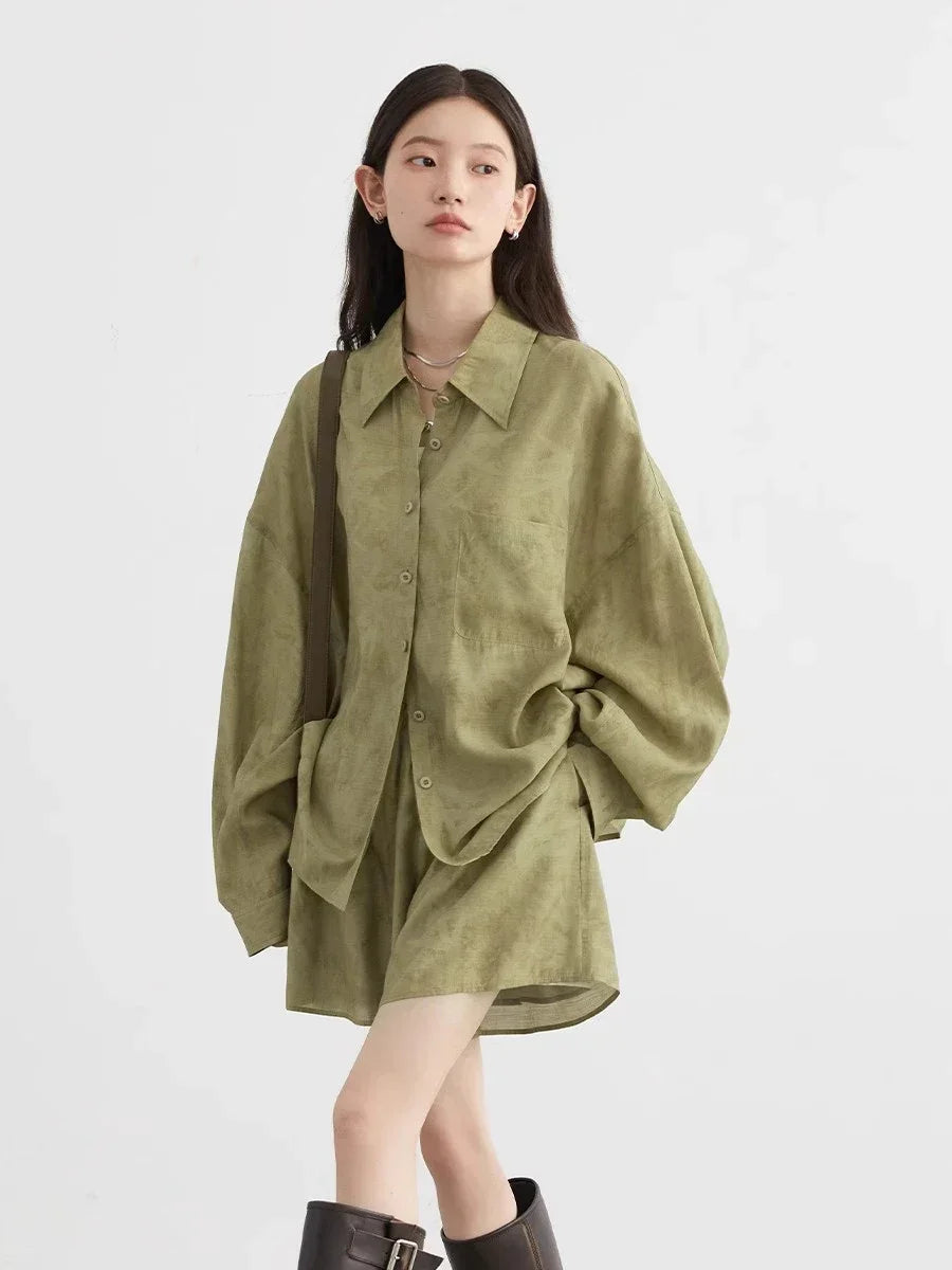 Woman wearing a green oversized shirt dress on a white background