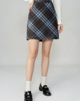 Person wearing a plaid skirt on a beige background
